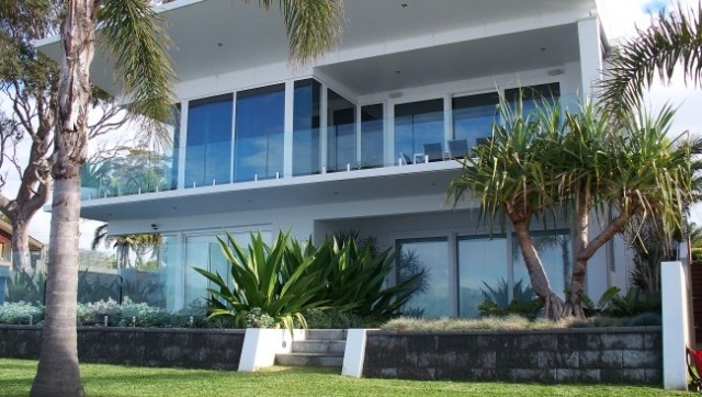 Platt tak hus-glas front landskap-palmer gräsmatta