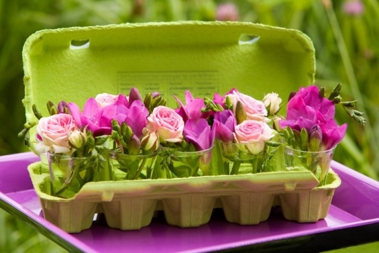 Minivas med blommor bukett äggkartong som skapar vårhumör