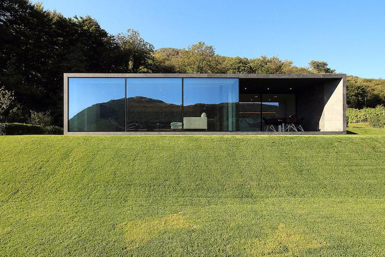 fin stengods-kakel-ventilerad-fasad-glasfasad-modern-arkitektur-gräsmatta-natur-berg