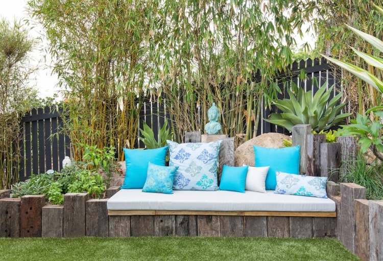 Feng Shui trädgårdsdesign trästolpar-sängkläder-blå-dekorativa kuddar-bambuväxter