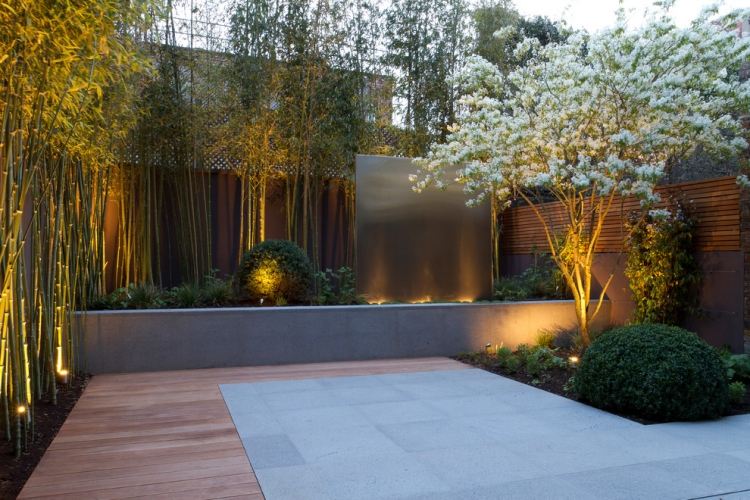 feng-shui-trädgårdsdesign-buxbom-häck-bambu-integritetsstaket-vit-blommande-träd-golvlampor