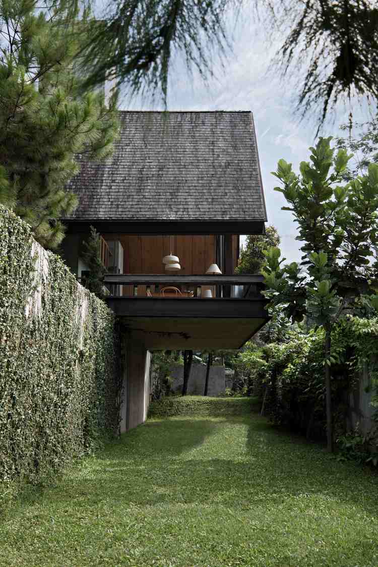 fritidshus gjord av trä skog perfekt tillflyktsort helg hus träbeklädnad glas fasad växter bakgård betongvägg gräsmatta träd