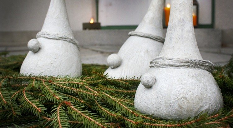 Skandinaviska pixies som trädgårdsdekorationer på vintern på tallgrön
