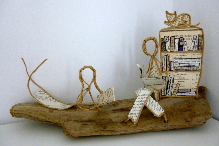 Tinkerfigurer och böcker i bokhyllor på trä med papperstråd