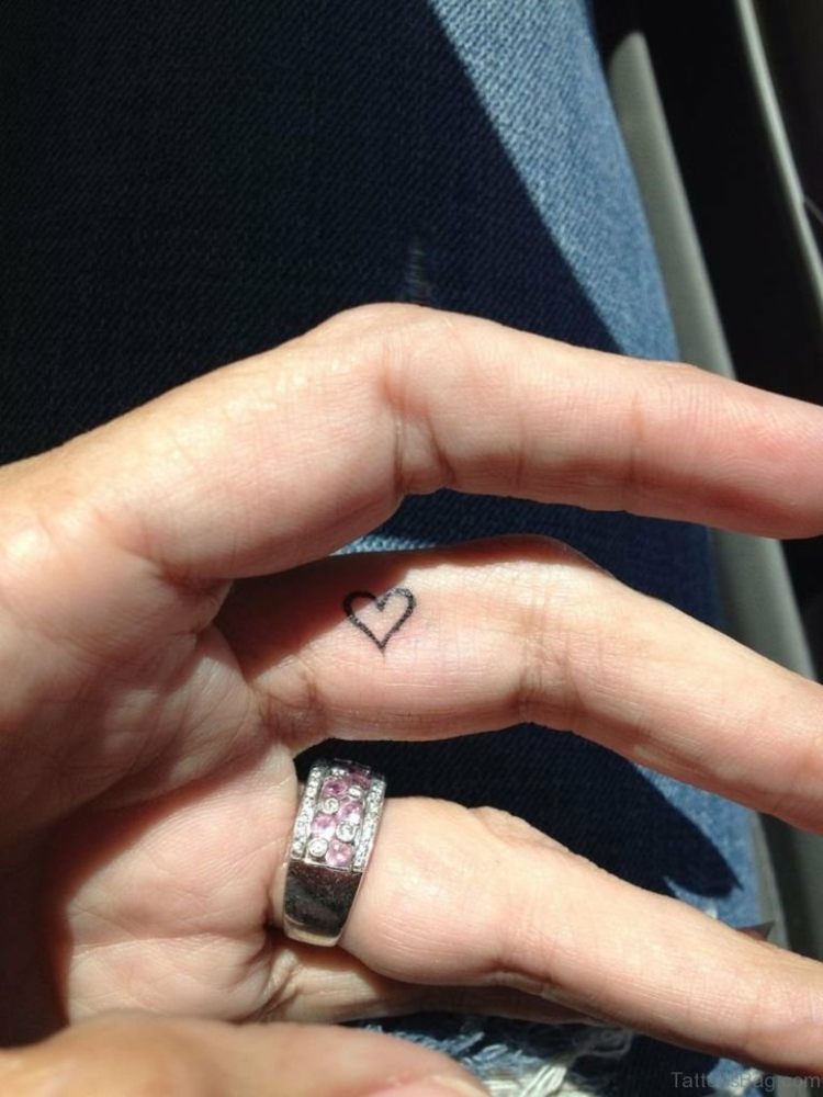 finger-tatuering-i sidled-långfinger-ring-sten-kvinna-hand-hjärta-liten