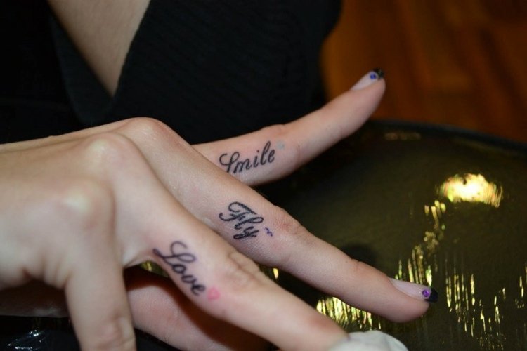 finger-tatuering-kvinna-händer-skriver-inuti-fingrar-hjärta-svälja-leende