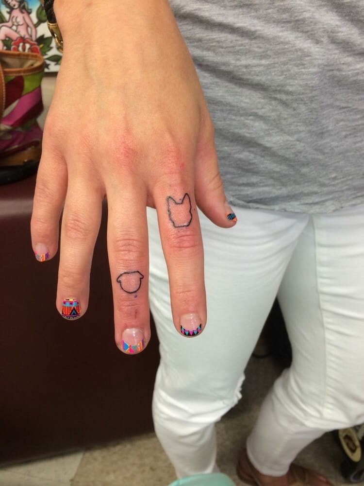 finger-tatuering-djur-konturer-pekfinger-bulldog-varg-kvinna-hand-nagellack-färgglada-mönster