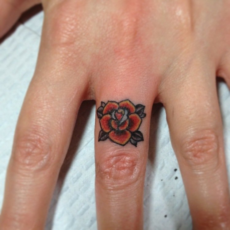 finger-tatuering-långfinger-kvinna-hand-ros-färgad-röd-gul