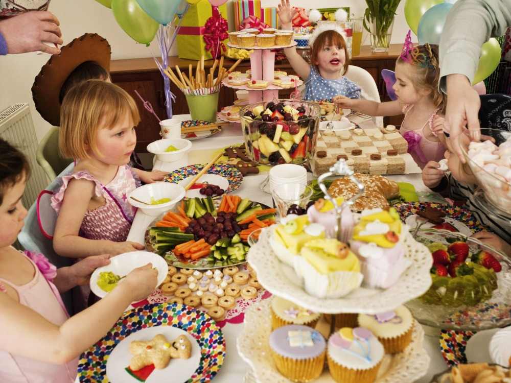 barn firar sin födelsedag med ett fullt bord med noggrant förberedda delikatesser