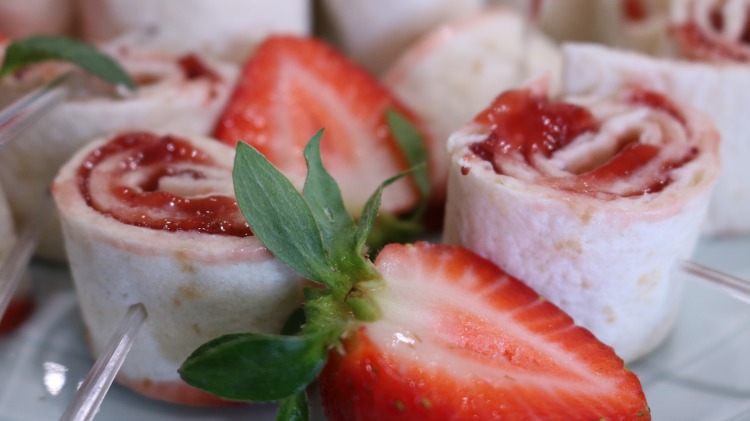servera fruktrullar med färskost och jordgubbssylt som snacks med sötmat med deco -plockare