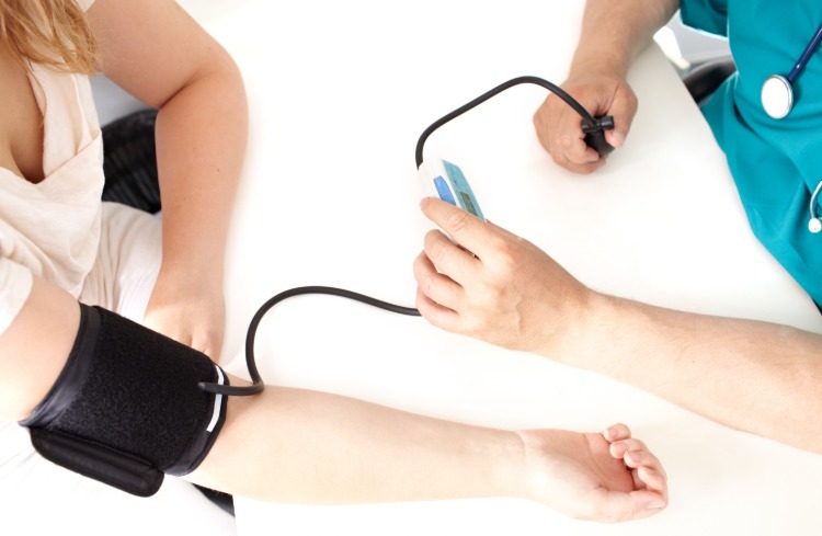 läkare med blodtrycksmätare undersöker patienten på sjukhuset