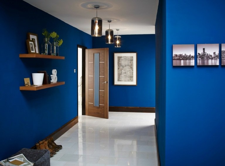 Entrén i kungsblå är designad av trähyllor och golvplattor i vitt