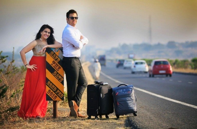 Roligt foto för att spara datumkortet på en landsväg med vägskylt och resväska