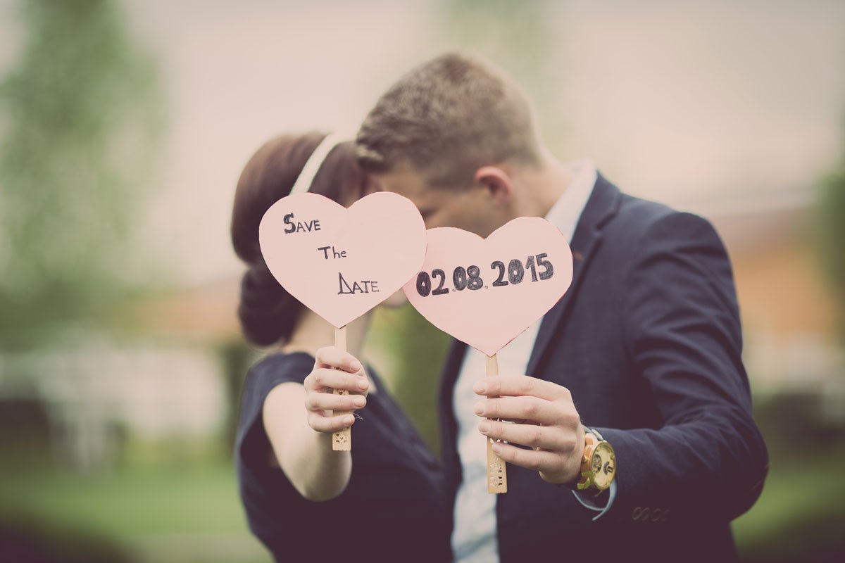 Designa skyltar med datumet som hjärtan och posera med en kyss