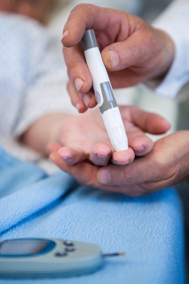 läkare testar insulin hos en patient med typ 2 -diabetes med hjälp av en blodsockermätare