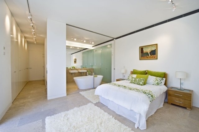 sovrum badrum ingen vägg säng badkar vit grön