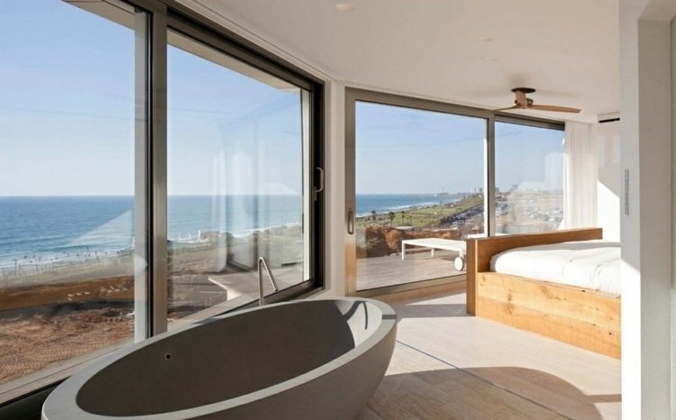 badkar-sovrum-trä-säng-stort-glas-havsutsikt
