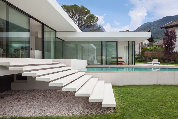 fristående familjehus modern byggnad arkitektur meran italien pool design en våning trädgård skjutbara glasdörrar trappor sidovy