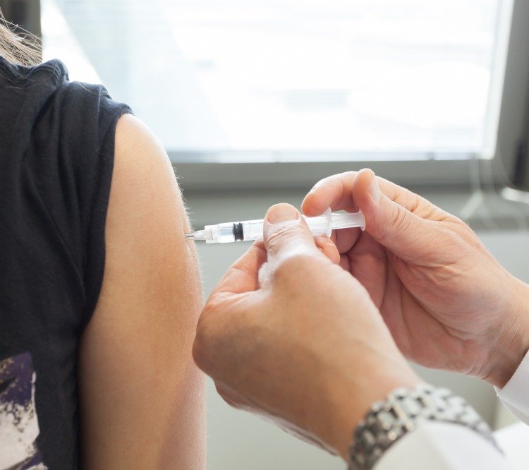 Läkare injicerar frivillig infektion med coronavirusvaccin i överarm på en patient