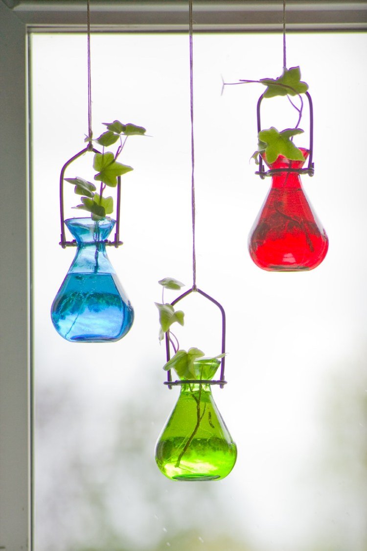 vår-dekoration-fönster-idéer-olika-färgade-glas-vaser-murgröna-hängande upp