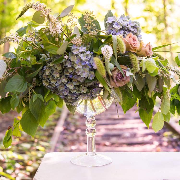 stort glas dekorera med vårblommor hortensia och rosor och druvor