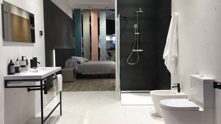 modernt badrum bredvid sovrum med texturer och tapeter i svartvitt