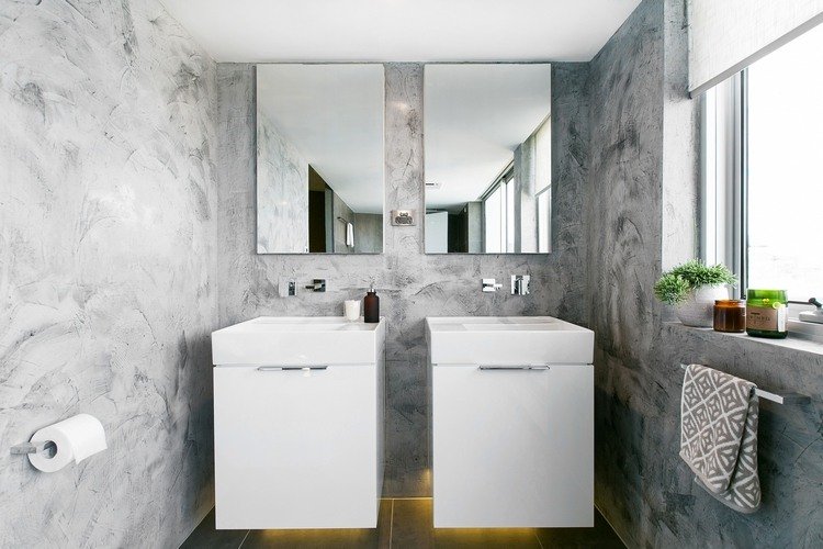 grå nyanser vägggips i badrummet med två handfat speglar integrerad golvbelysning