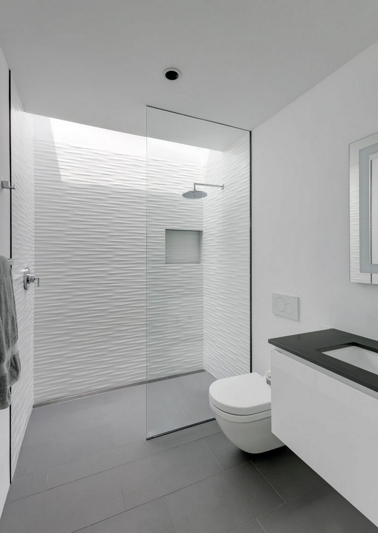 minimalistiskt badrum vitgrått skiljevägg i glasvägg