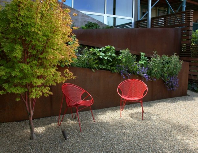 Trädgård sluttning två röda stolar corten stål höga blomsterbäddar