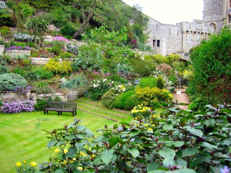 trädgård på sluttningen skapa romantisk design terrass gräsmatta bänk