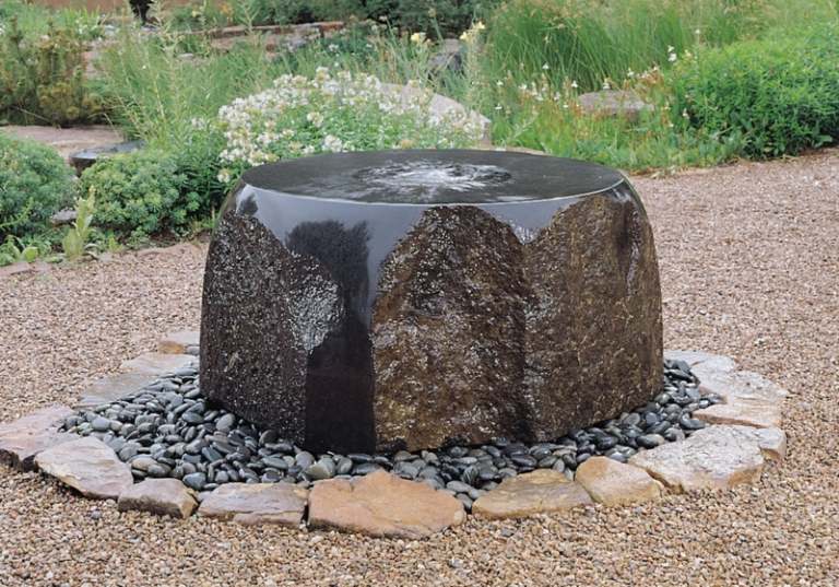trädgård fontän gjord av sten obearbetade svarta sten flis dekoration