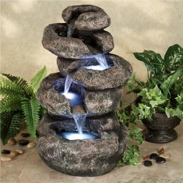 trädgård fontän källa dekorativa stenar blå belysning