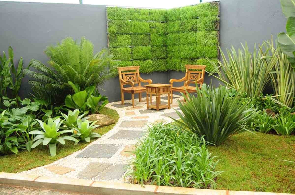 trädgård med vertikal växtvägg och trämöbler