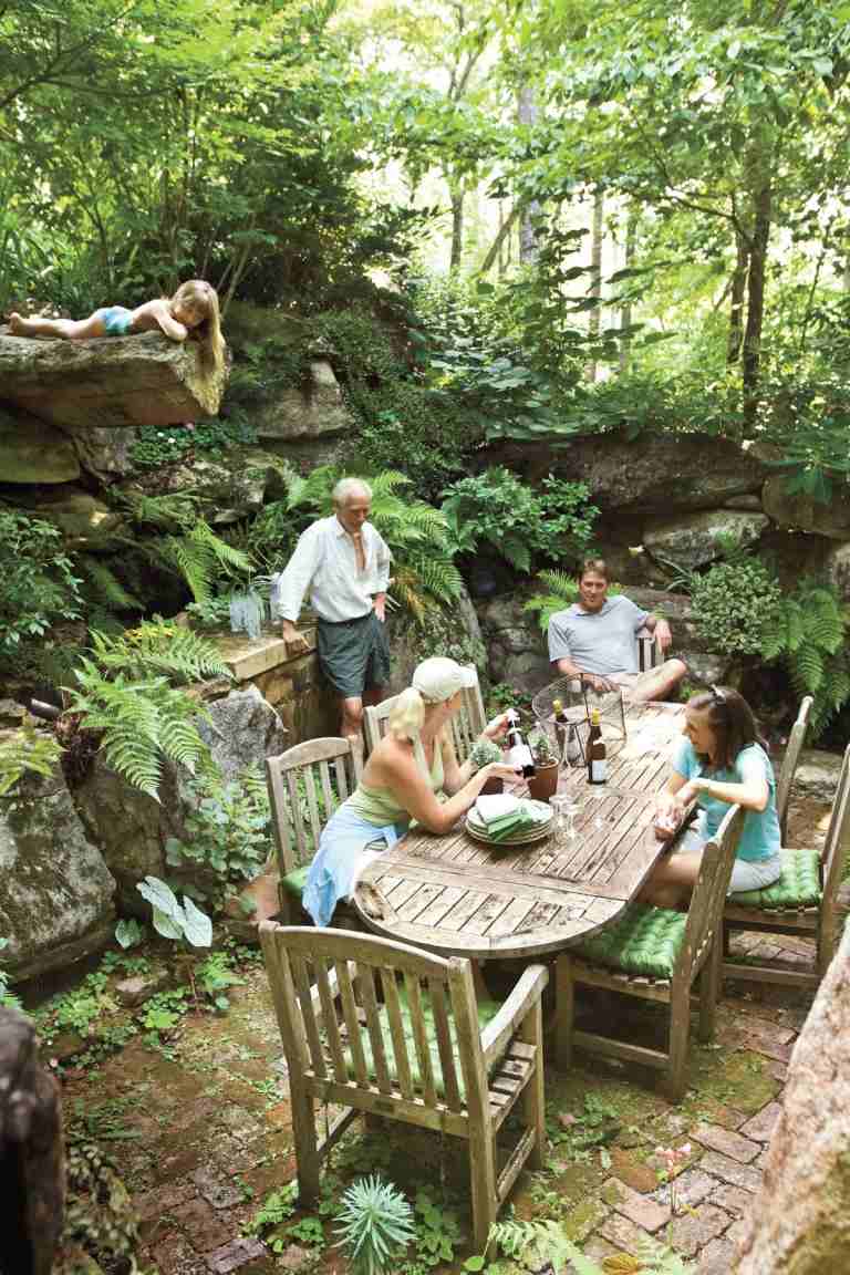 intressant design med stenar och stenar och ett trädgårdsbord för gäster