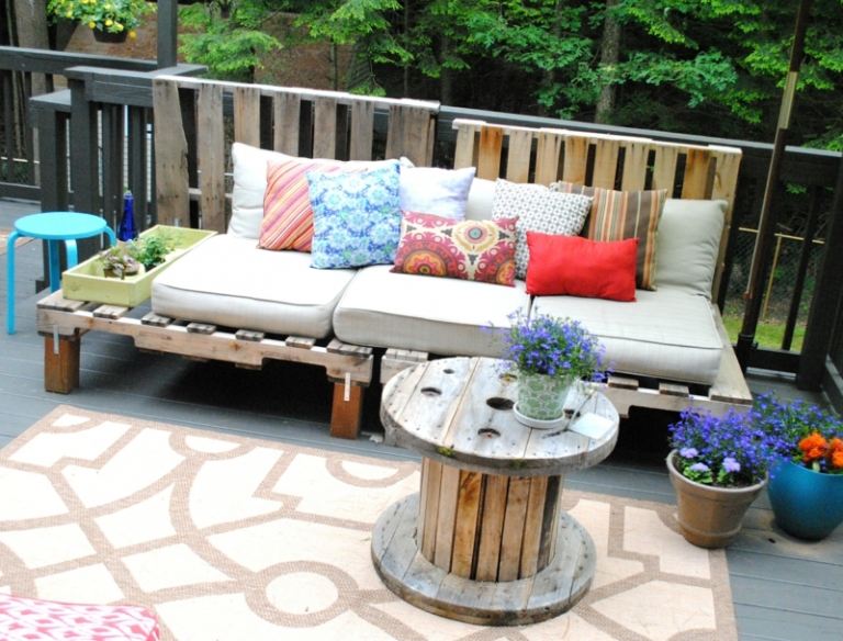 trädgård bänk gjord av träpallar soffa veranda idé spole soffbord kasta kuddar blommor