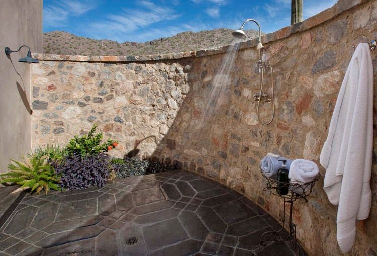 välvad stenmur och rustikt lagt golv i duschområdet med medelhavsdesign