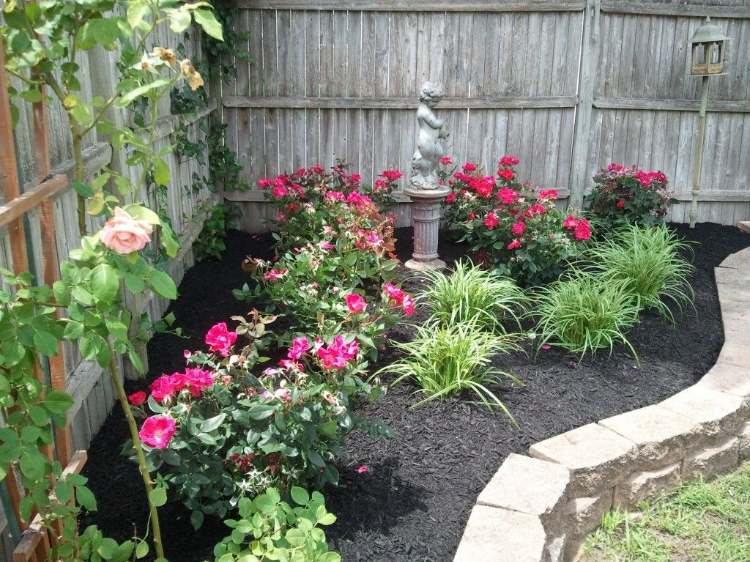 Trädgårdshörn design med växter rosor trädgård statyett