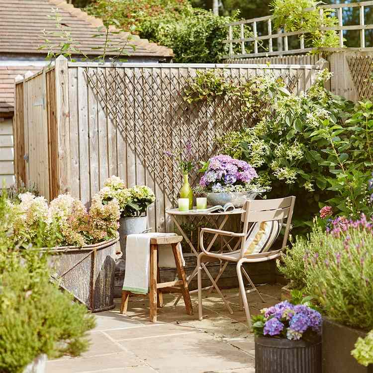 Litet trädgårdshörn design trädgård bord klättring växter staket