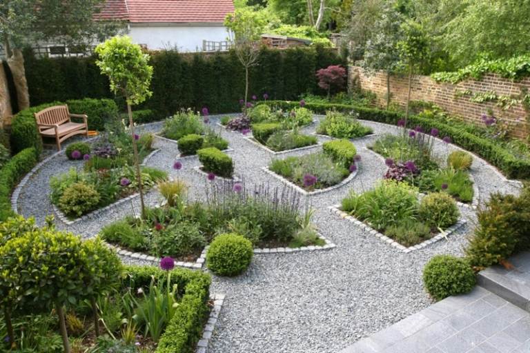 trädgård design med grus rabatter häckar träd moderna stenplattor