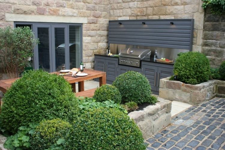 trädgård-design-med-terrass-grill-boxwood-trottoar-natursten-bord