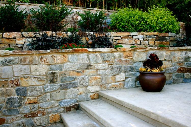 Trädgård design terrass modern natursten vägg perenner utanför trappan