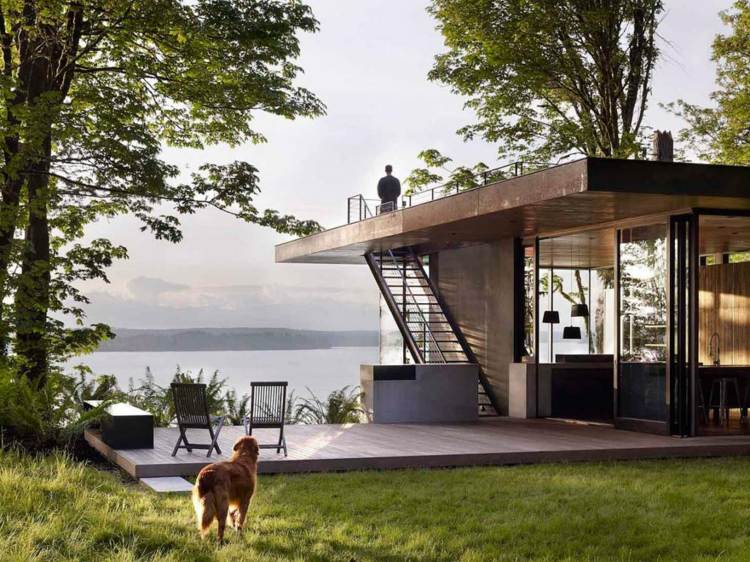 trädgårdshus med terrass takterrass-trappor-utsikt-sjö-stolar-träplattform-hund-man-natur-träd-hängande lampor