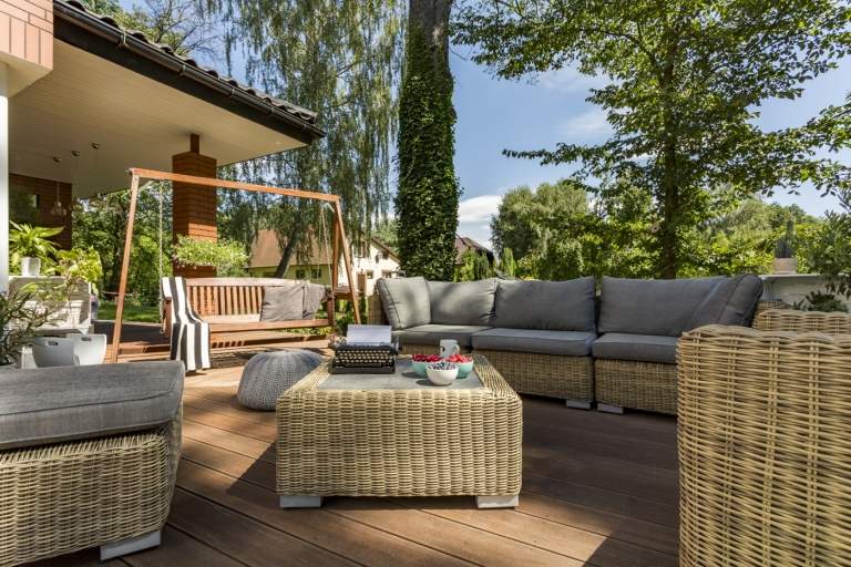 Loungemöbler som består av en modulär soffa och pall eller soffbord och en veranda gunga på den rymliga träterrassen