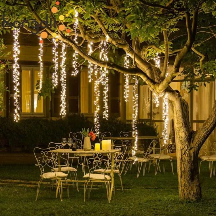 Vertikalt hängande älvlampor på ett träd för en romantisk fest