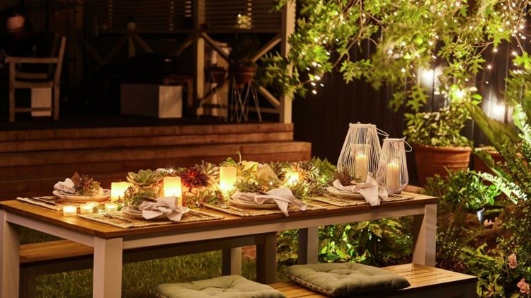 Ljus som bordsdekorationer i trädgården för en romantisk festatmosfär på kvällen