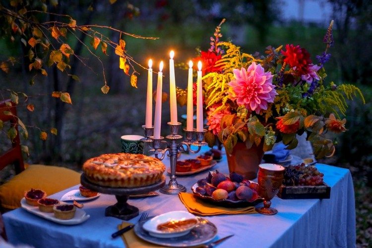 Trädgårdsfestljus på bordet och blommor i vaser