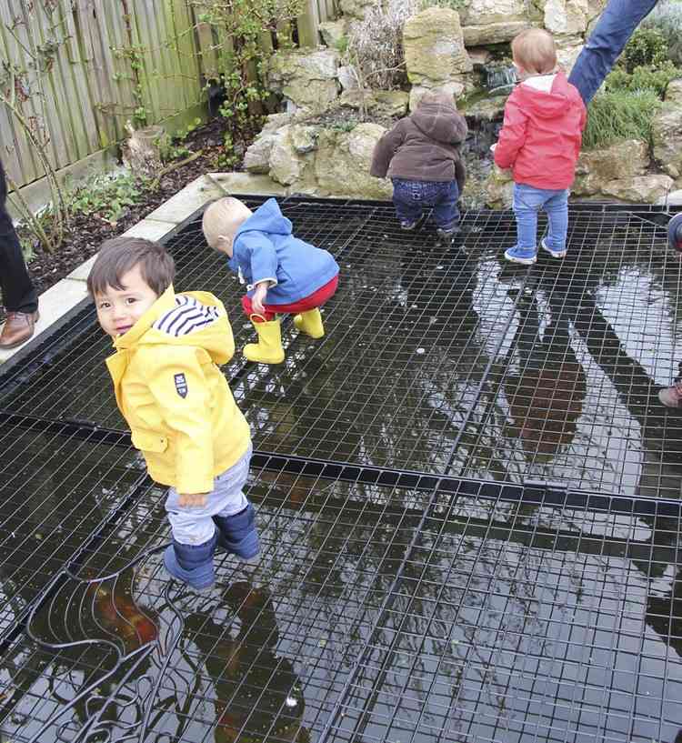 Trädgårdsdamm-gör-barnsäker-täck-galler-små-barn-titta på prydnadsfiskar