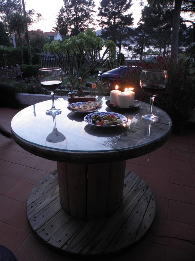 trädgårdsbord av trä-glasplatta-kabelrulle-romantisk-atmosfär-middag