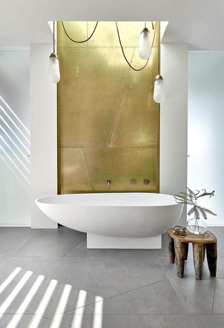 dämpade färger badrum guld metallplatta badkar fristående golvplattor i stort format