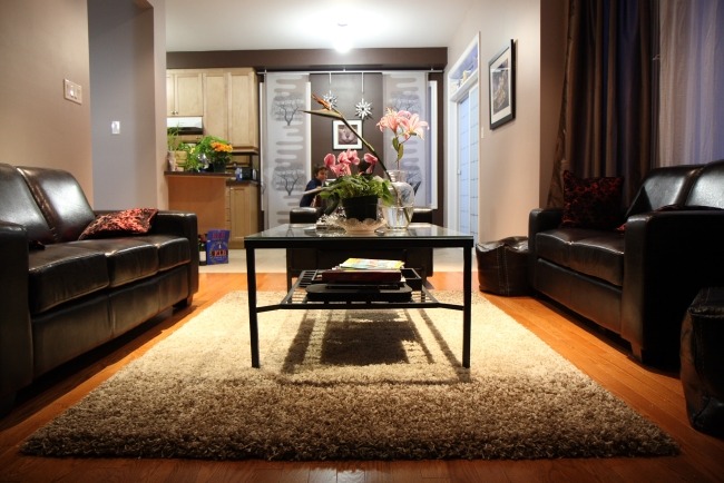 trägolv shaggy matta svart läder möbler vardagsrum